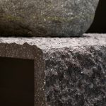 E34 Bruno PF ROCKCRUST - a heavily textured dark brown stone with corner joint